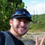 Man in front of tress with a smile