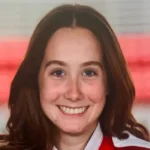 Girl smiling for camera with red background