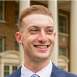 Man smiling in front of building