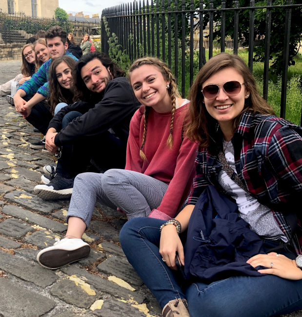 People sitting against a fence posing for the camera